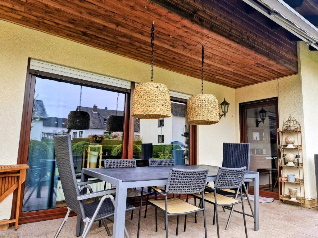 a dining room table and chairs on a patio at Haus am Twistesee in Wetterburg