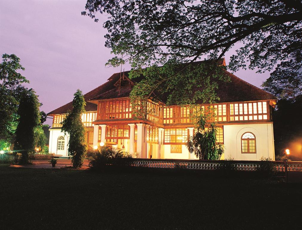 una casa grande con techo de gambrel por la noche en Bolgatty Palace & Island Resort, en Kochi