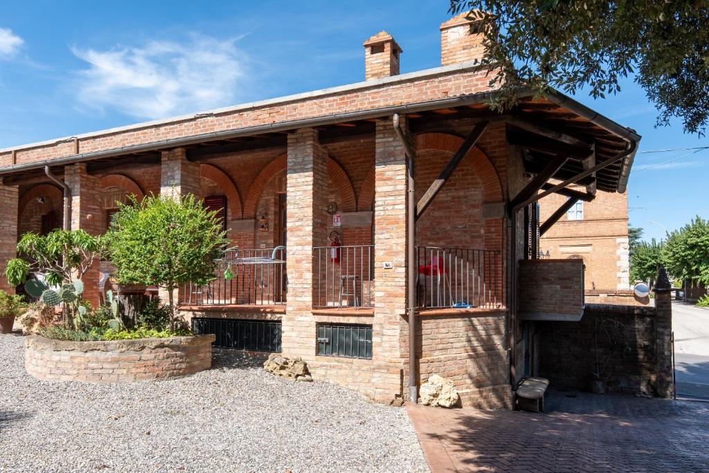 an old brick building with a porch on a street at Casa Isidora in Acquaviva