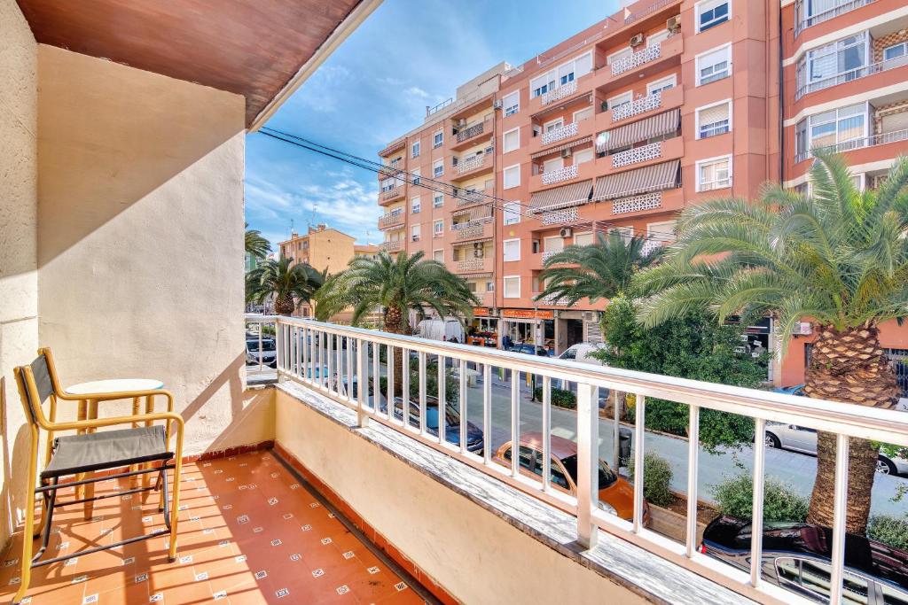 a balcony with a chair and a building at Paseo el Saladar in Denia