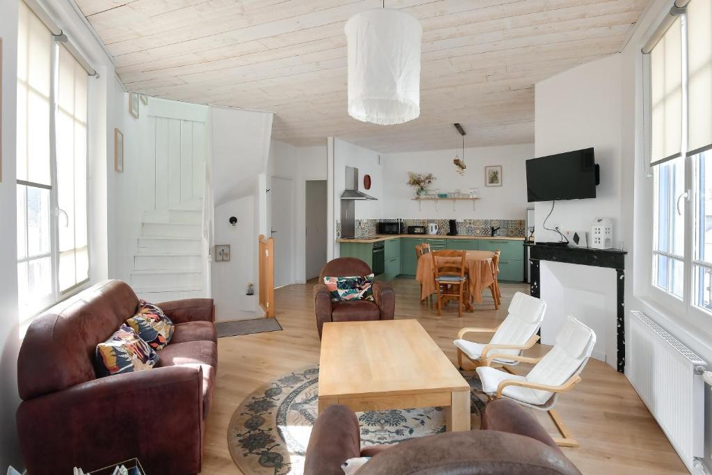 a living room with leather furniture and a table at La Pointe Du Crotoy in Le Crotoy
