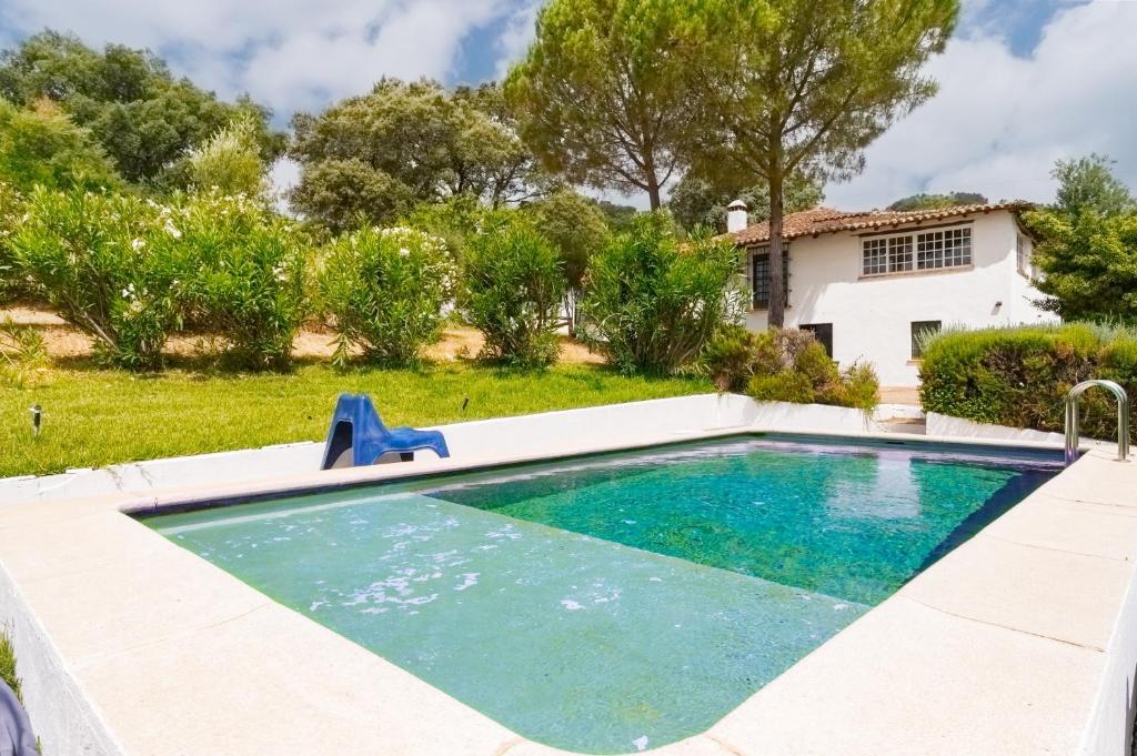ein Swimmingpool in einem Garten mit einem Haus in der Unterkunft Collado in Alájar