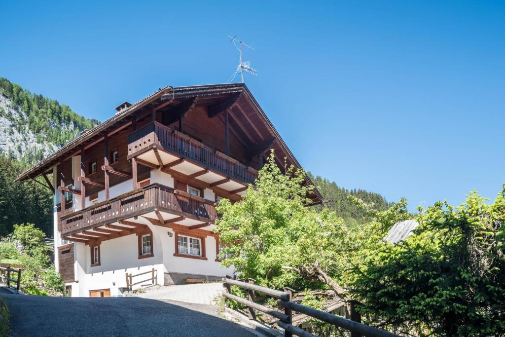 a house in the mountains with a fence at Casa Lorenz 4 in Canazei