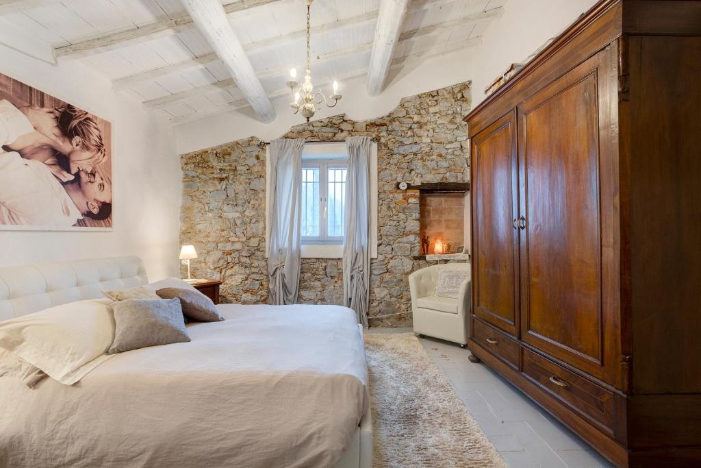 a bedroom with a large bed and a stone wall at Casa Collicello relax in Camaiore