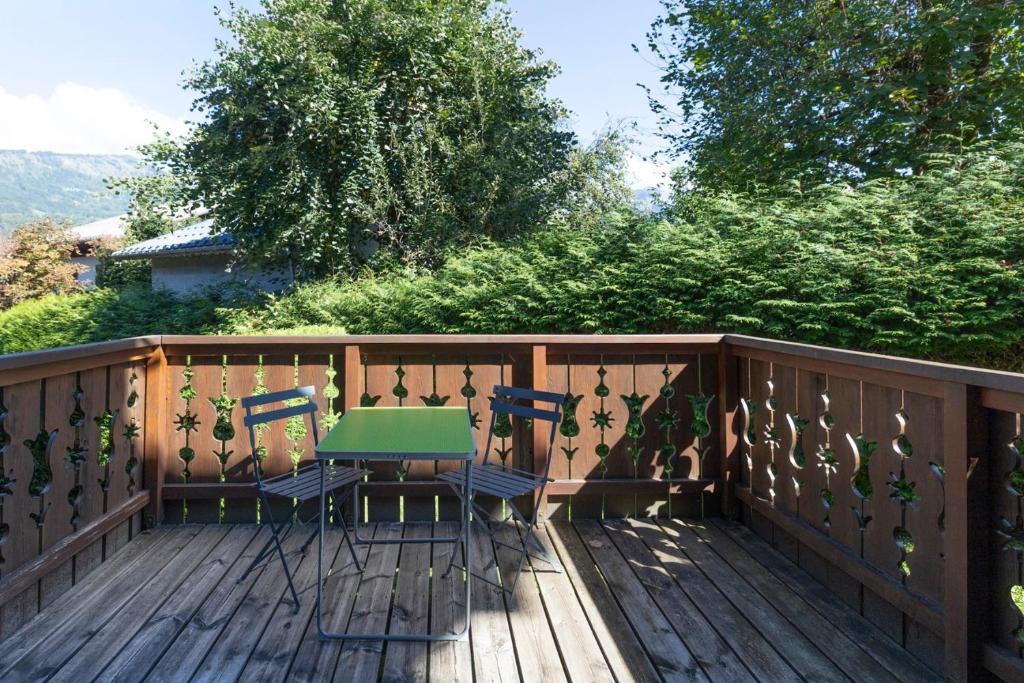a patio with a table and chairs on a deck at L’Edelweiss Pied des Pistes in Morillon