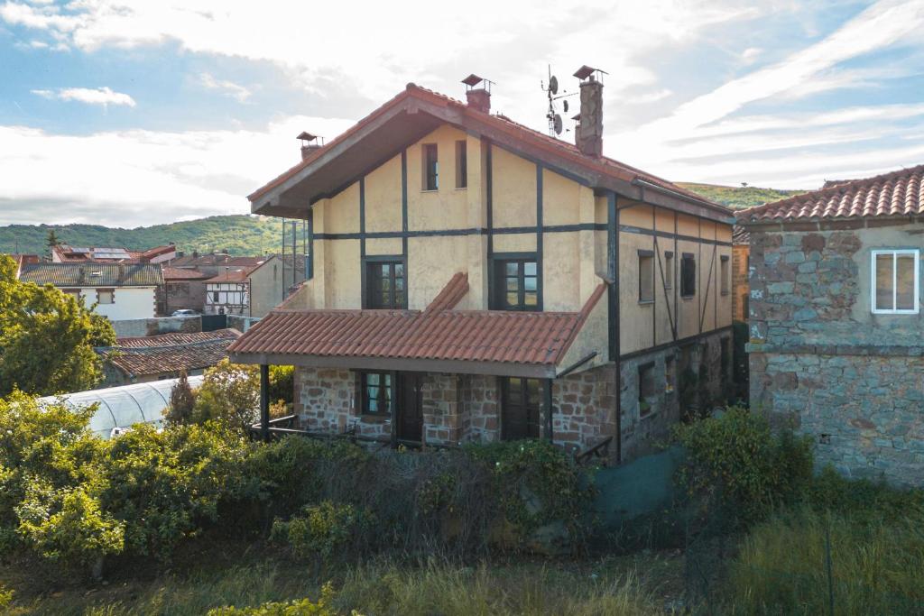 an old house with a red roof on a hill at Casa Rural De Cabrera in Urrez