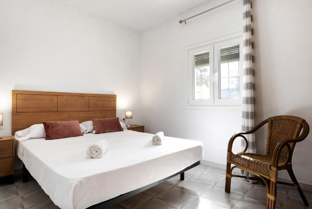 a bedroom with a large white bed and a chair at Villa Montenmedio 2 in El Soto