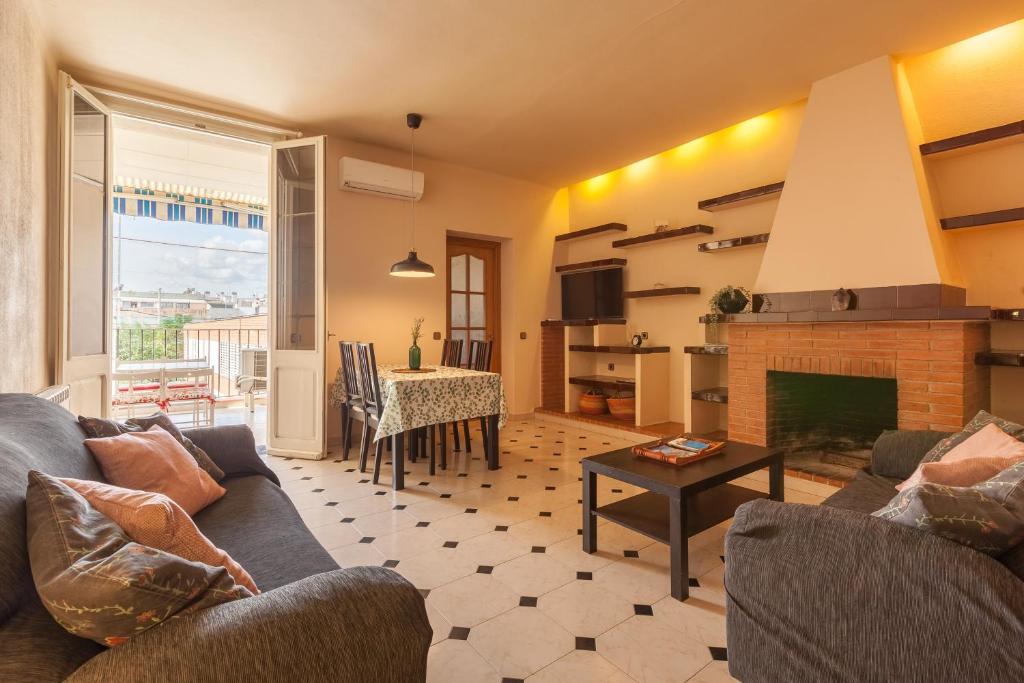 a living room with a couch and a fireplace at Sant Pere in Mataró