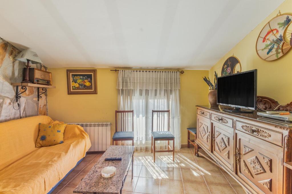 a living room with a couch and a tv at El Tejado in Maluenda