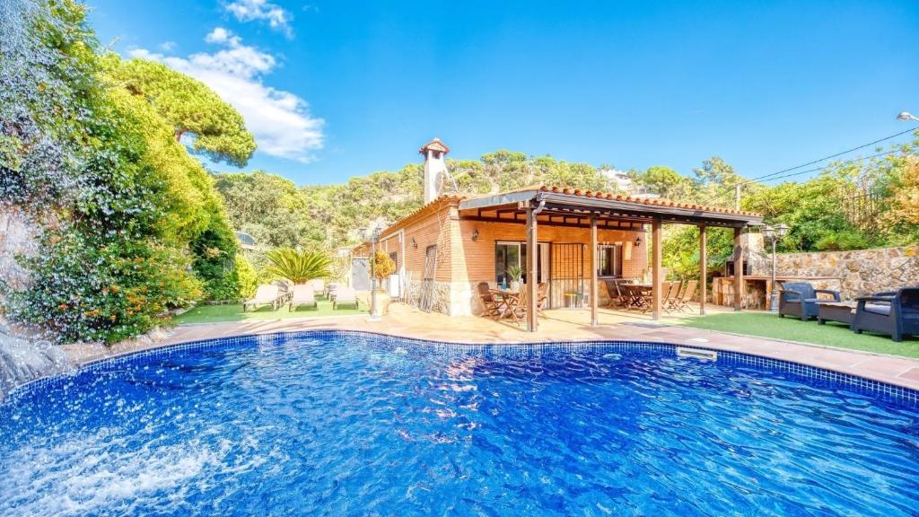 a swimming pool in the backyard of a house at Costacabana - Villa Alba in Lloret de Mar