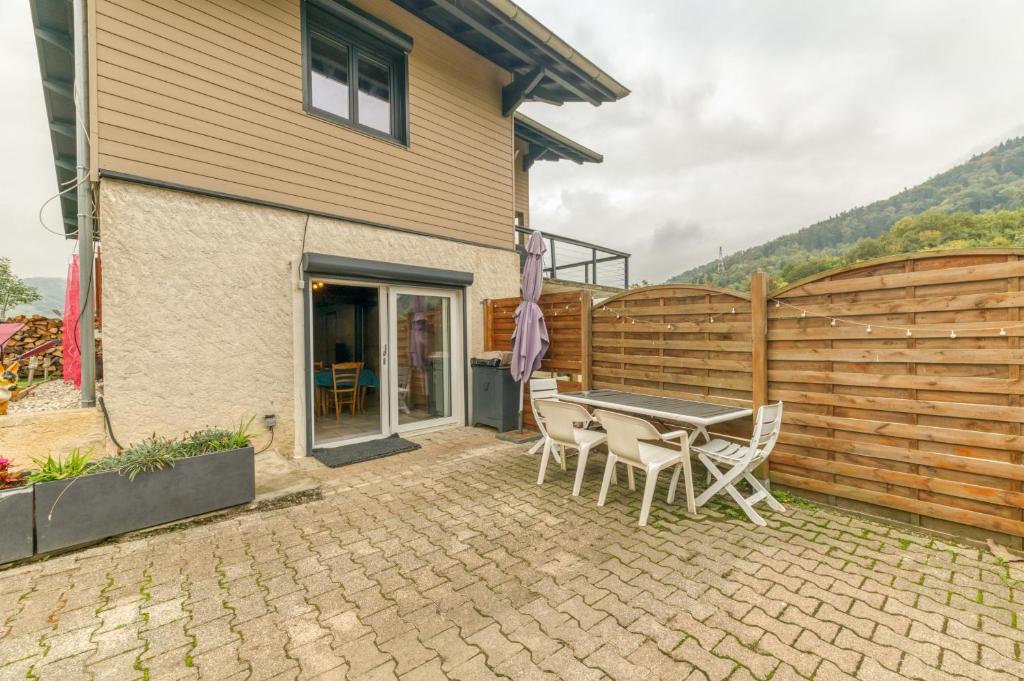 a patio with a table and chairs and a fence at Appartamento In Chalet in Murianette
