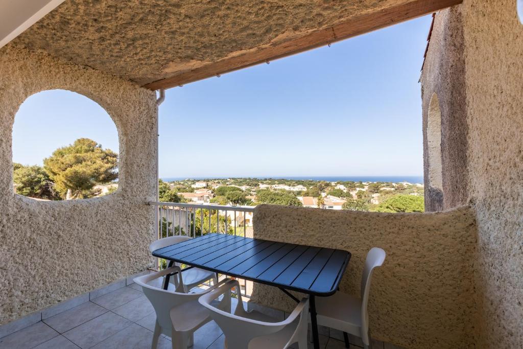 a table and chairs on the balcony of a house at Marina de Sant Ambroggio in Lumio