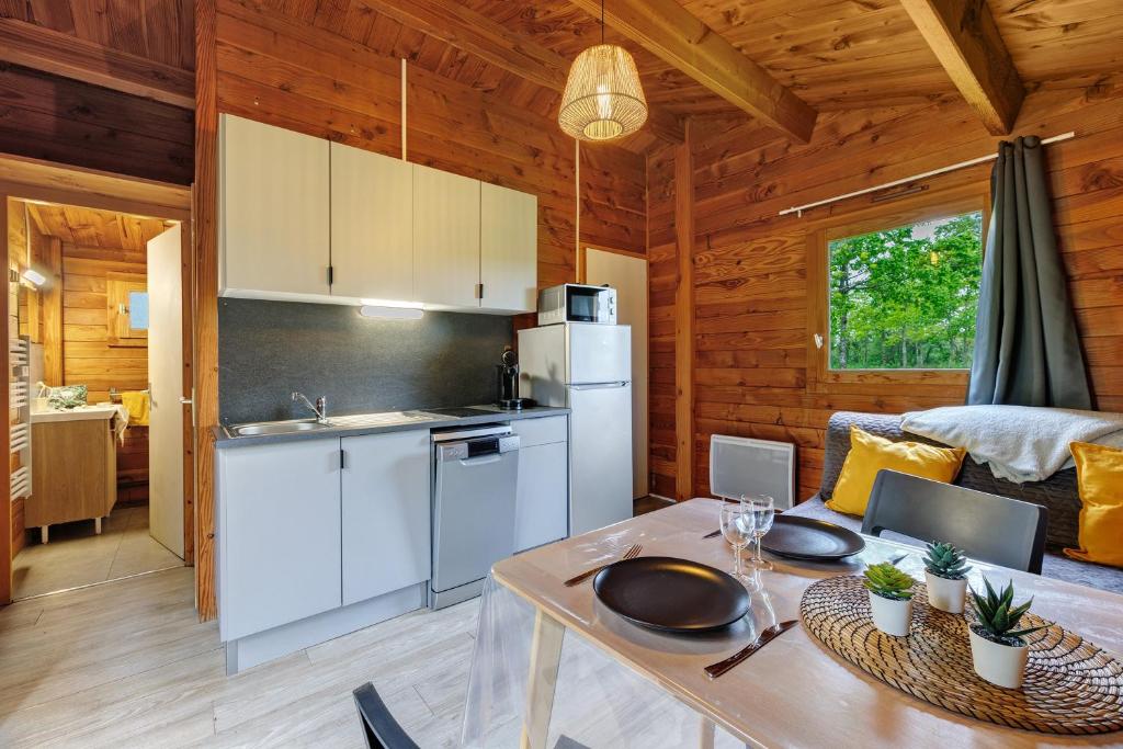 a kitchen and living room in a log cabin at Chalet prestige 19 piscine partagée in Saint-Gervais