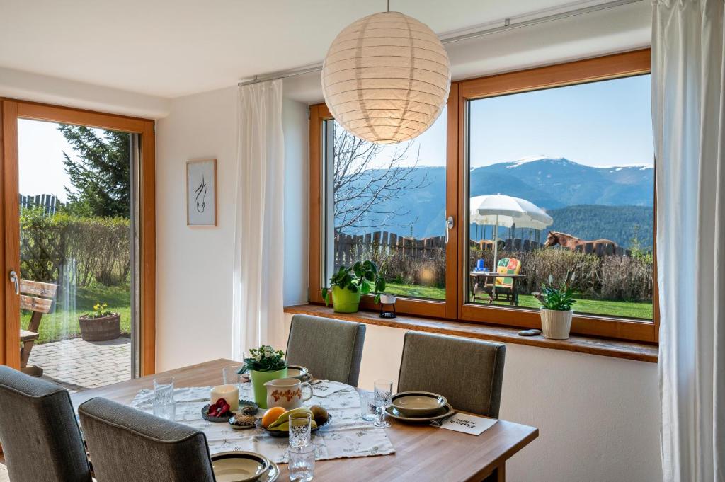 a dining room with a table and a large window at Gunzhof in Kastelruth
