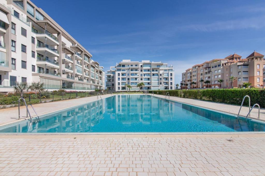 an empty swimming pool in the middle of two apartment buildings at Los Flamencos in Isla Canela