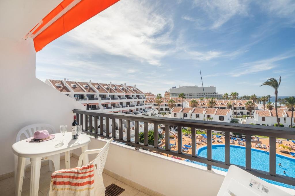 a balcony with a table and chairs and a view of the pool at Santiago Beach in Costa Adeje