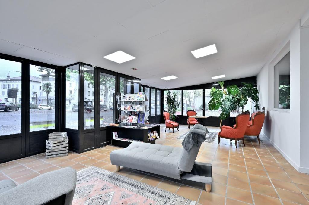 a living room with a couch and chairs and windows at Villa Milady 2 in Salies-du-Salat