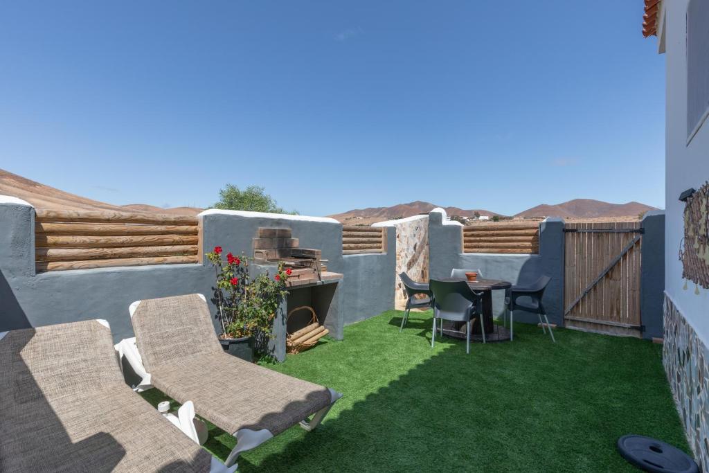 a patio with chairs and a table on the grass at Casa Suárez in Tuineje
