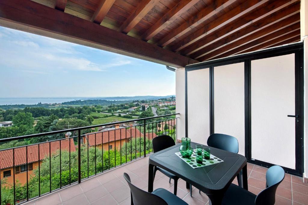 a balcony with a table and chairs and a view at vista lago apartment 2 in Soiano del Lago