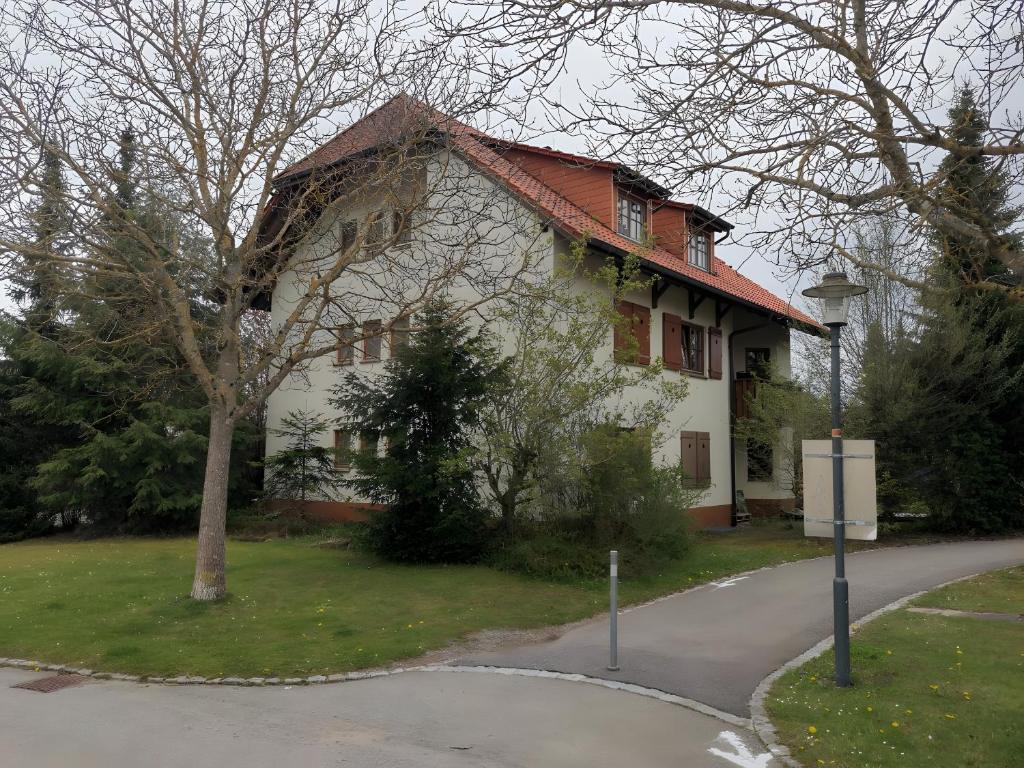 a white house with a red roof on a street at Ferienwohnungen Leiteritz in Königsfeld im Schwarzwald