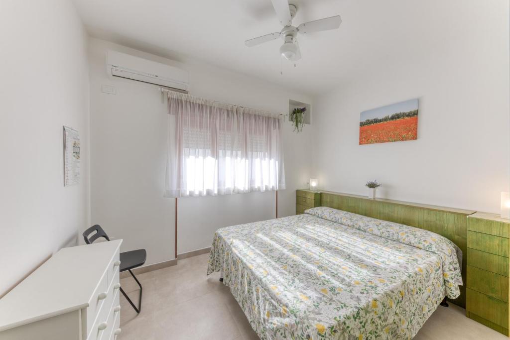a bedroom with a bed and a desk and a window at Franza 1 in Torre San Giovanni Ugento