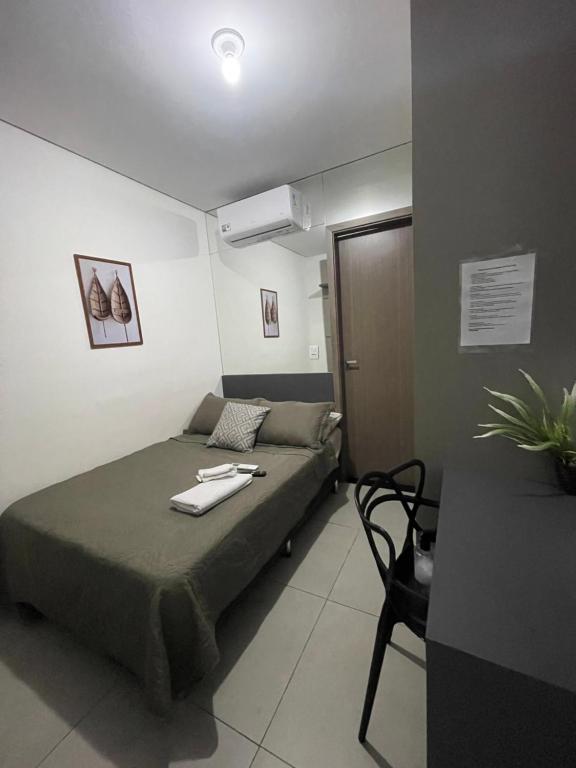 a small room with a bed and a table at Absolut Residense in João Monlevade