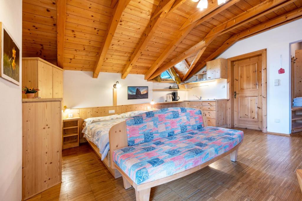 a bedroom with a couch in a room with wooden ceilings at Lindenhof Apt 3 in Vandoies