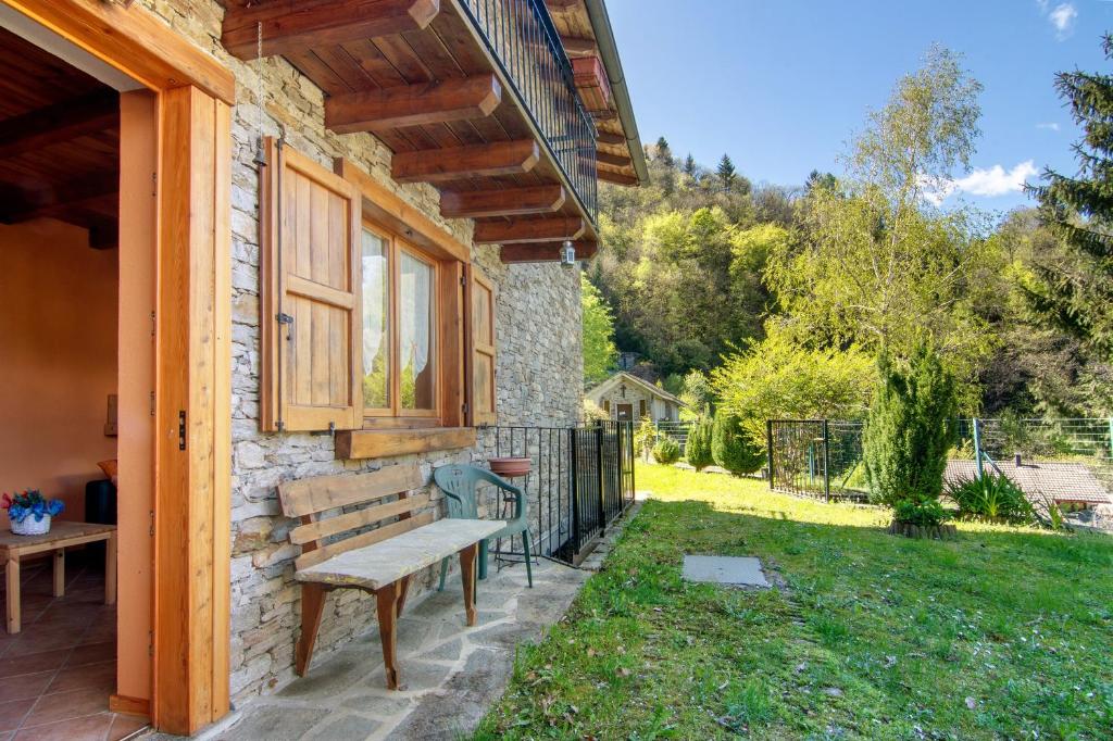 a bench on the side of a house with a yard at Piantina Holiday Home in Sacco