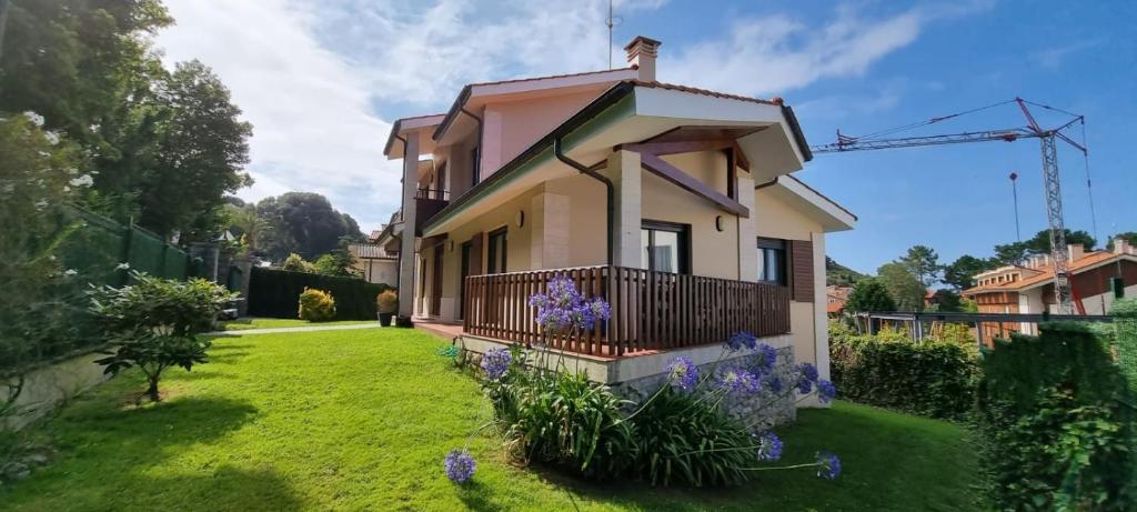 a house with a green yard with purple flowers at Casa La Marina in Llanes