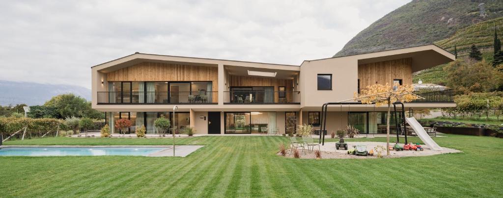 a house with a large yard with a swimming pool at Trianglhof surrounded by vineyards in Bolzano