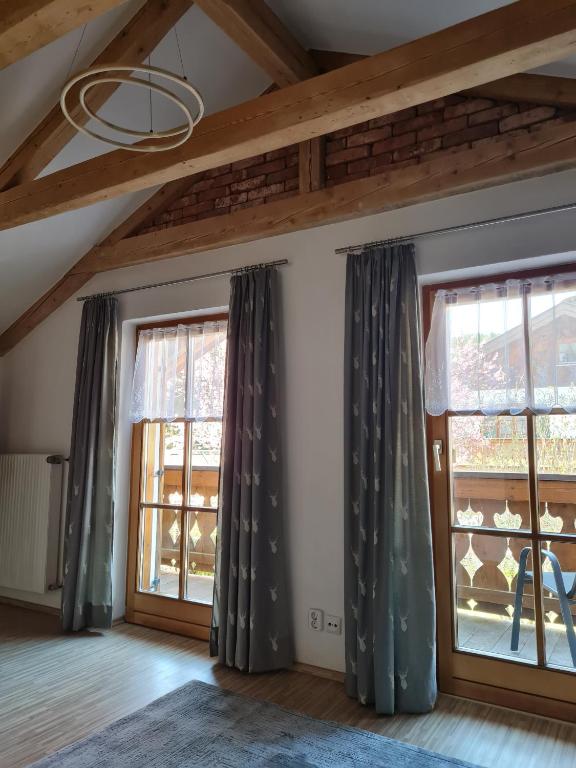 a room with two large windows with curtains at Ferienwohnung Wetterstein in Mittenwald