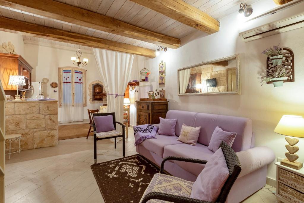 a living room with a purple couch and a chair at Alghero Old Town Gem - Sardinia in Alghero