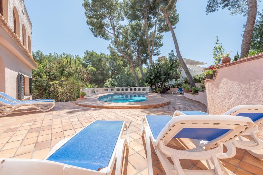 a patio with chairs and a swimming pool at Villa Costa De Blanes in Calvià