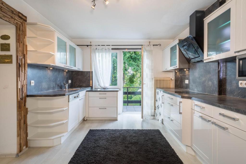 a kitchen with white cabinets and a large window at Ferienwohnung Idylle in Wasserburg