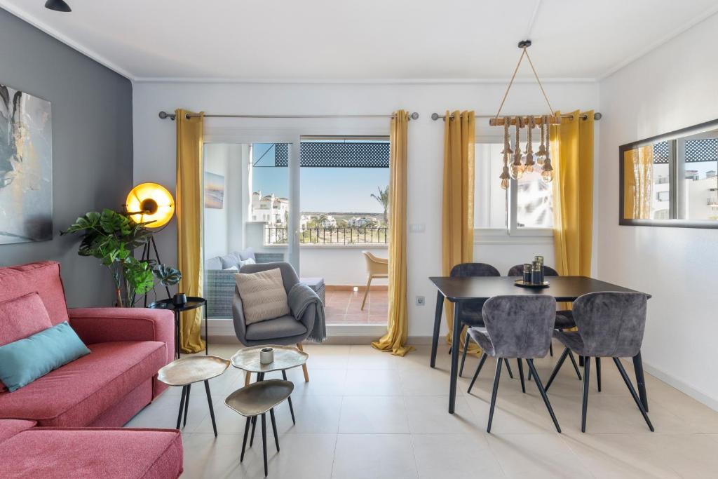 a living room with a pink couch and a table at Casadeluxe Riquelme in Sucina