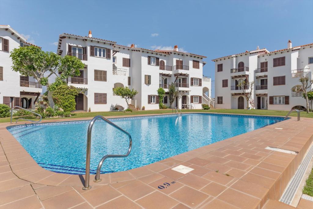 a swimming pool in front of some apartment buildings at La Gardenia 41 in Es Castell
