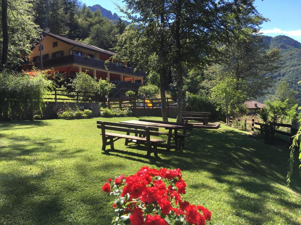 a park with benches and flowers in the grass at Le Terrazze sul Lago - Ledro House in Pieve Di Ledro