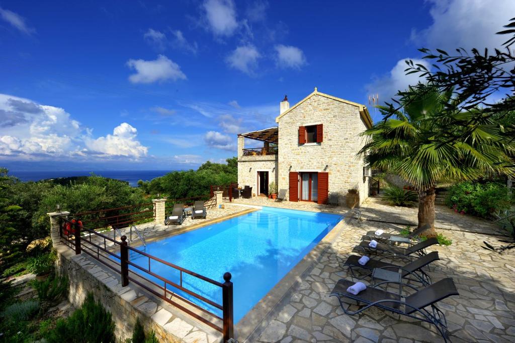 a villa with a swimming pool in front of a house at Villa Casa Bianca Orange Apartment in Gaios