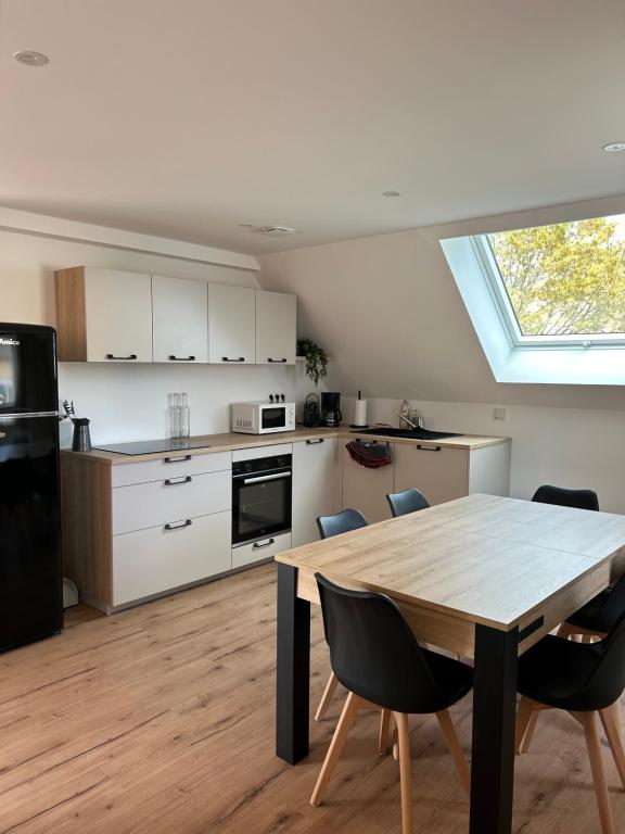 a kitchen with a table and chairs in a room at La parenthèse in Artolsheim