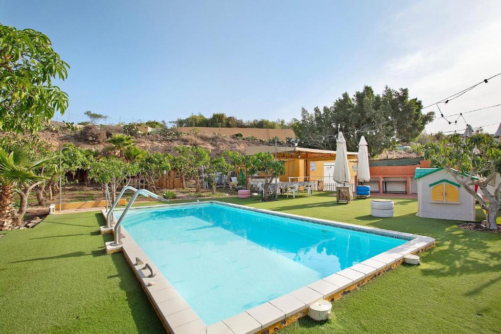 a swimming pool in a yard with grass at Finca Vidalenta El Salobre in Salobre