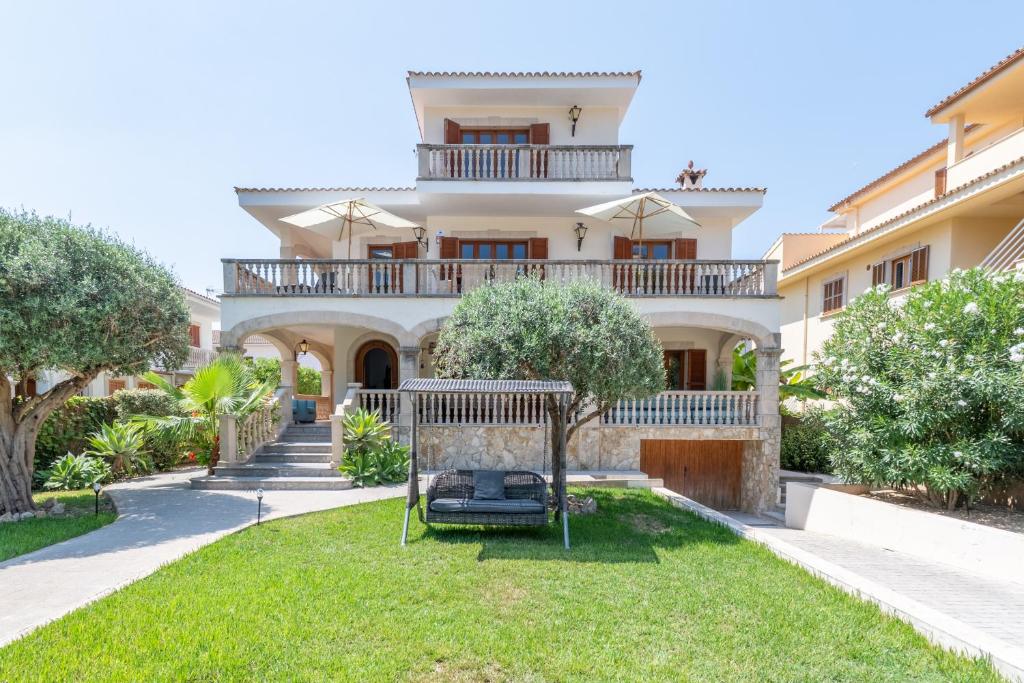 a large house with a yard with a swing at Voramar Alcudia in Alcudia