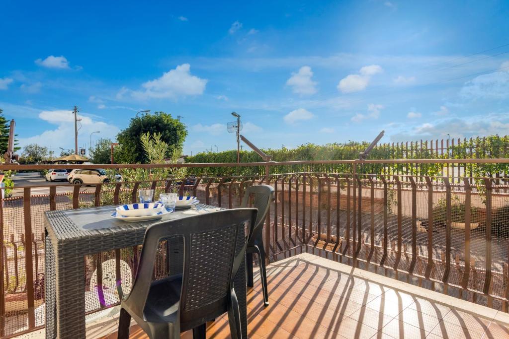 a patio with a table and chairs on a deck at Da Pina E Lu in Giardini Naxos