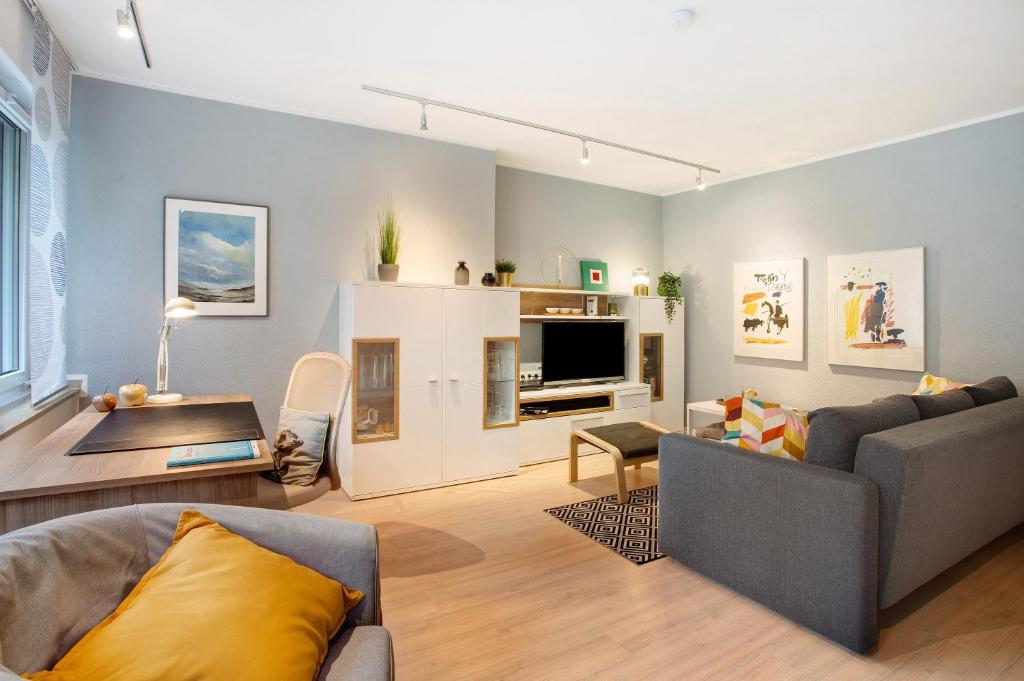 a living room with a couch and a tv at Stadt Land Fluss Plus in Arnsberg