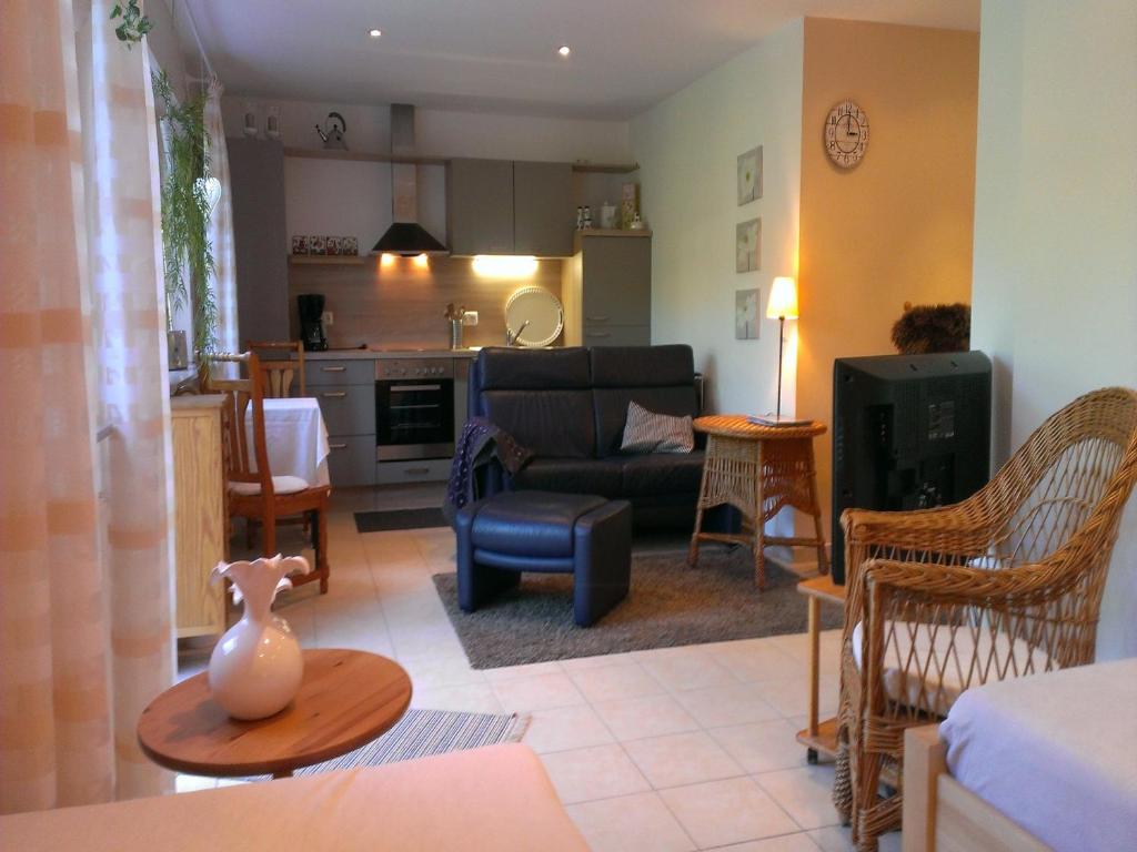 a living room and kitchen with a couch and a table at Ferienwohnung Schwanbergblick in Mainbernheim