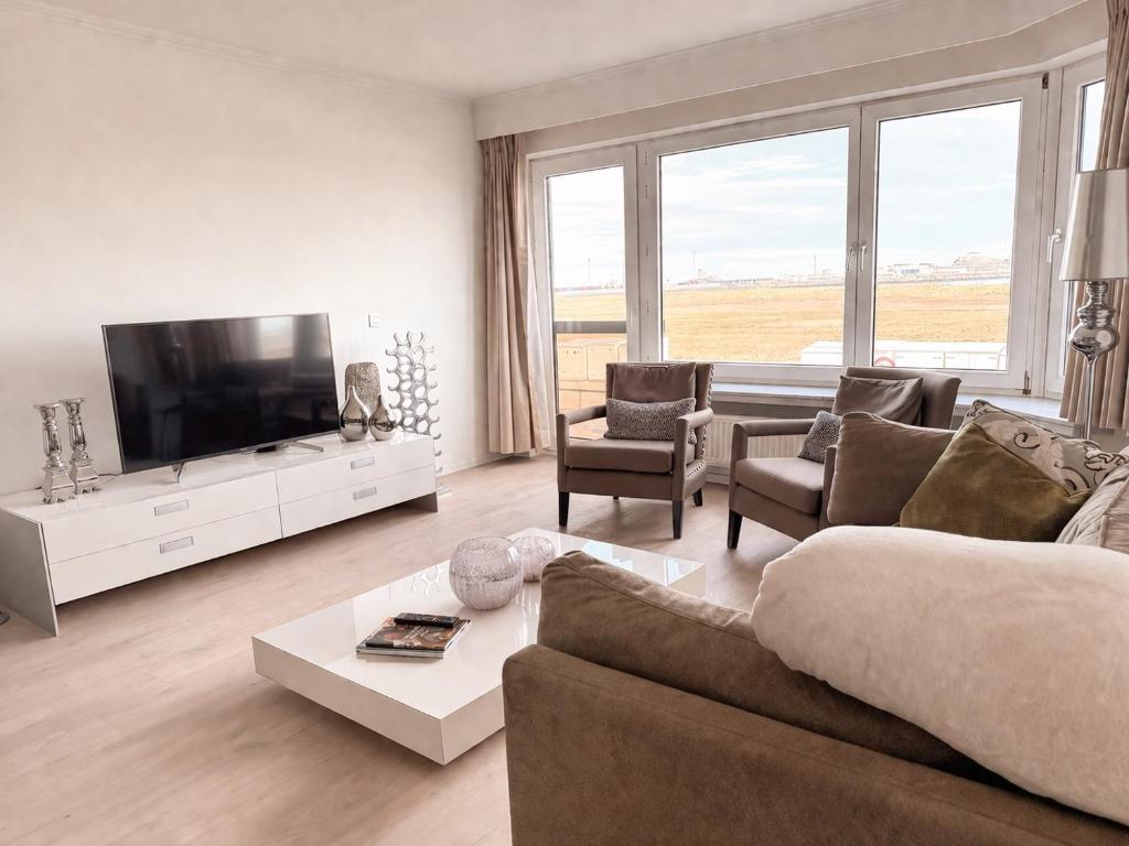 a living room with a couch and a flat screen tv at Anna's Haven, Knokke in Knokke-Heist