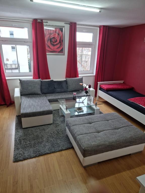 a living room with red curtains and a couch at Große 4 Zimmerwohnung Zwickau in Zwickau