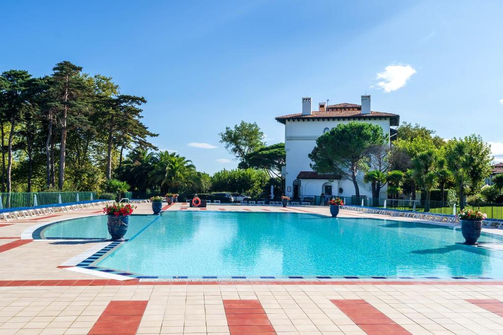 a swimming pool with a building in the background at Côte Basque in Urrugne