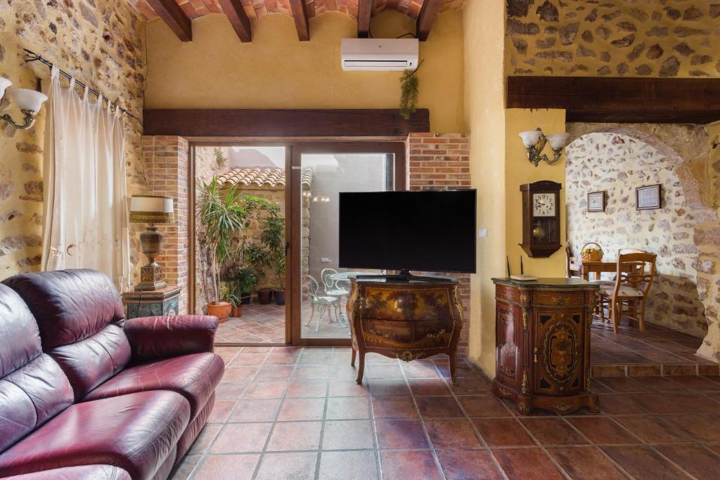 a living room with a couch and a flat screen tv at Siglo 16 Denia in Denia