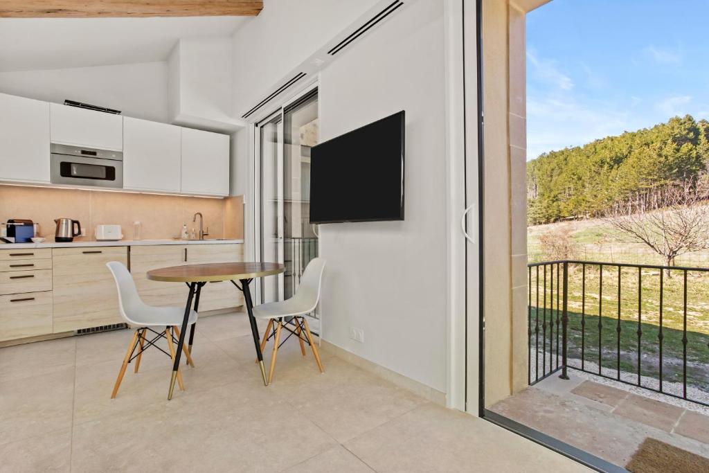 a kitchen with a table and chairs and a balcony at La Master Grange De Queyran in La Palud-sur-Verdon