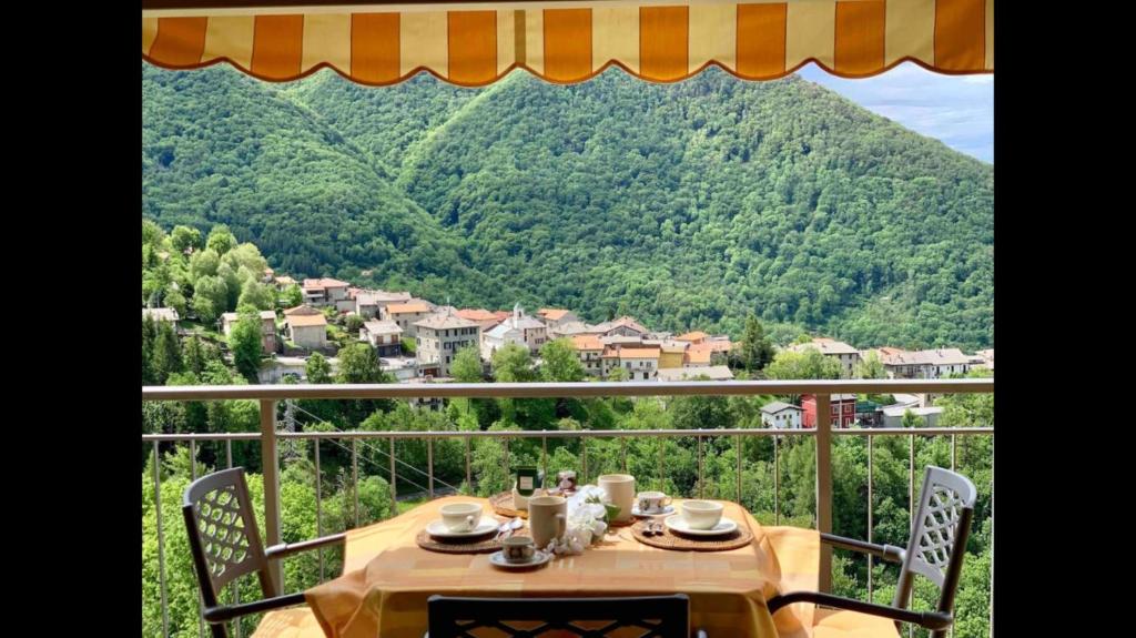 a table on a balcony with a view of a mountain at Splendido loft panoramico in Veleso